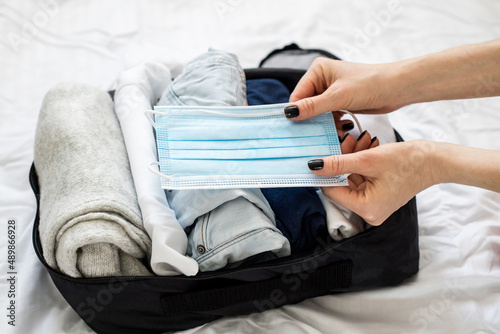 Packing clothes, documents into the suitcase. Travel concept, packing up before departure.