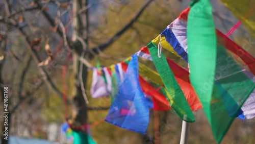Slow motion shot of colorful Buddhist prayer flags in front of mountains at Manali, Himachal Pradesh, India. Buddhist flags waving in the air at Manali. 
