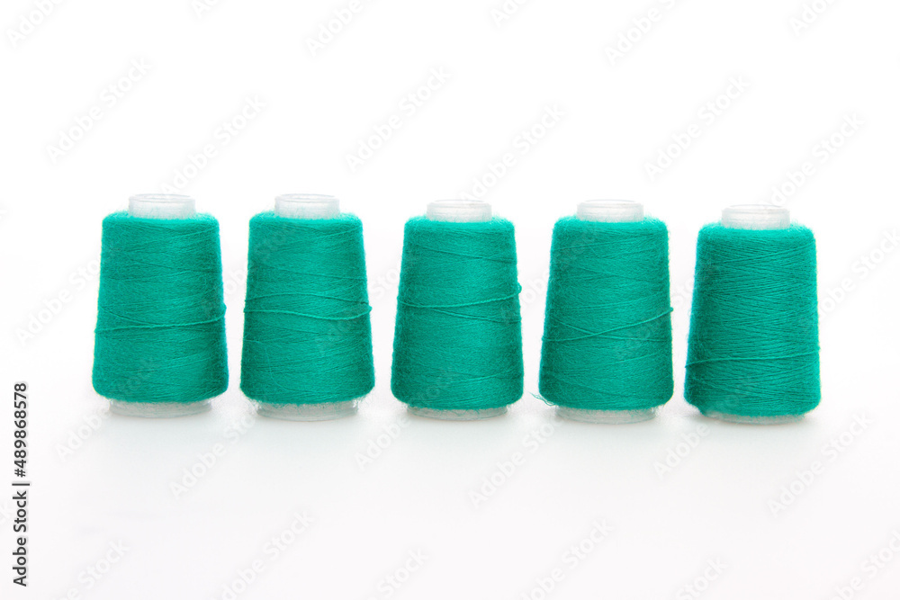 Green spool of thread isolated on white background. Skein of woolen threads. Yarn for knitting. Materials for sewing machine. Coil Green spool of thread isolated on white background. Skein of woolen threads. Yarn for knitting. Materials for sewing machine. Coil