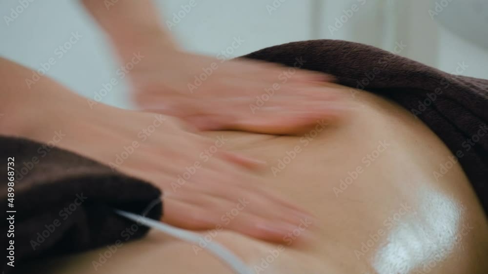 Getting massage at spa club. Hands massaging young woman with clear skin. Concept of body care and alternative medicine Getting massage at spa club. Hands massaging young woman with clear skin. Concept of body care and alternative medicine
