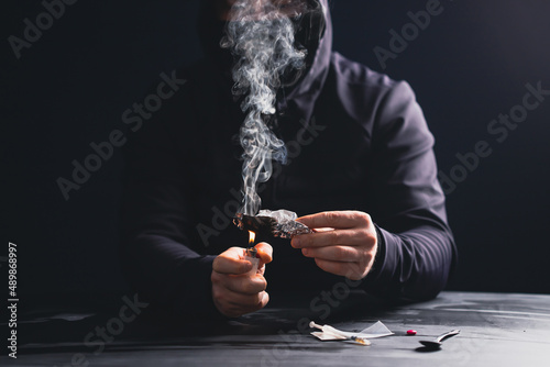 Foto Drug addict man or drug dealer prepares heroin.