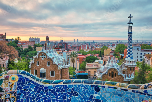 Barcelona city view from Guell Park with colorful mosaic buildings in tourist attraction Park Guell in the morning on sunrise. Barcelona, Spain