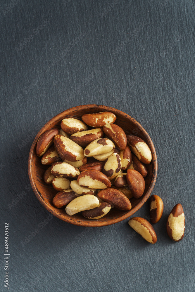 Tasty brasil nuts on gray slate background, most renowned for their high selenium content Tasty brasil nuts on gray slate background, most renowned for their high selenium content