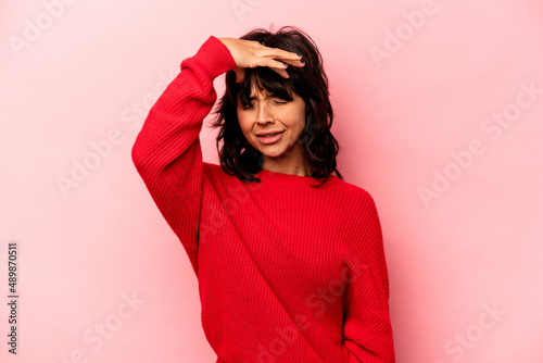 Young hispanic woman isolated on pink background touching temples and having headache. © Asier