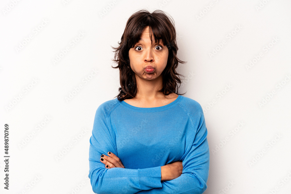 Young hispanic woman isolated on white background blows cheeks, has tired expression. Facial expression concept. Young hispanic woman isolated on white background blows cheeks, has tired expression. Facial expression concept.