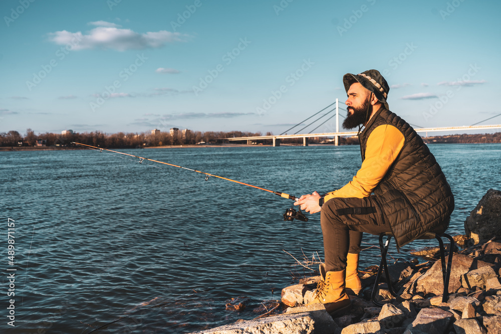 Man enjoys fishing by the river. Man enjoys fishing by the river.