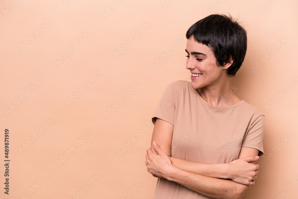 Obraz premium Young caucasian woman isolated on beige background smiling confident with crossed arms.