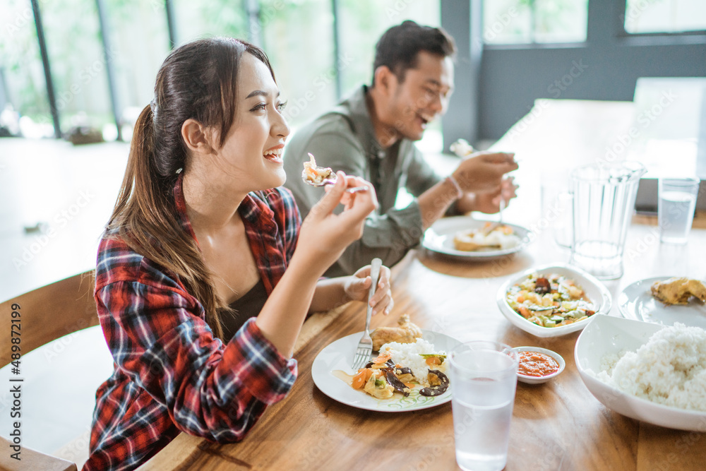 asian young people eating lunch together in the kitchen