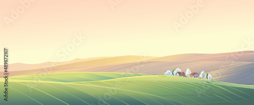 Spring rural landscape with hills and fields and village, on top of a hill.