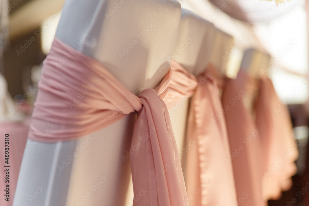 Obraz premium Beautiful pink and white wedding presidium for just married, arm-chairs with decorative fabric, close up shot