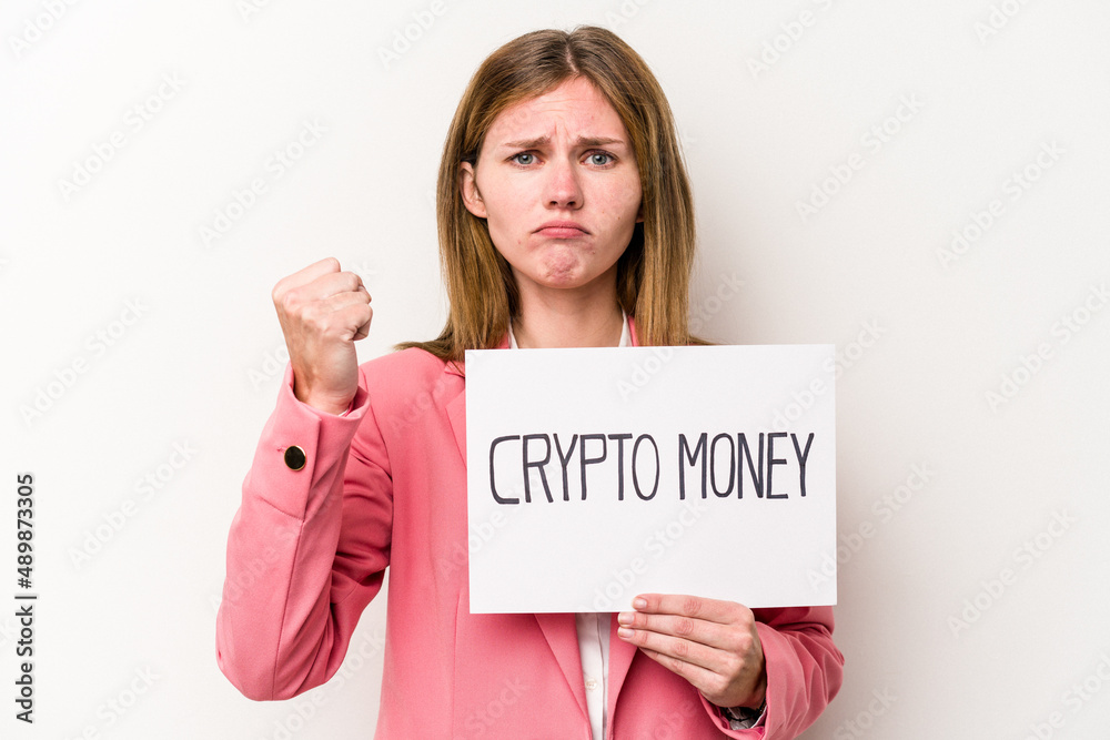 Young English business woman holding a crypto money placard isolated on white background showing fist to camera, aggressive facial expression. Young English business woman holding a crypto money placard isolated on white background showing fist to camera, aggressive facial expression.