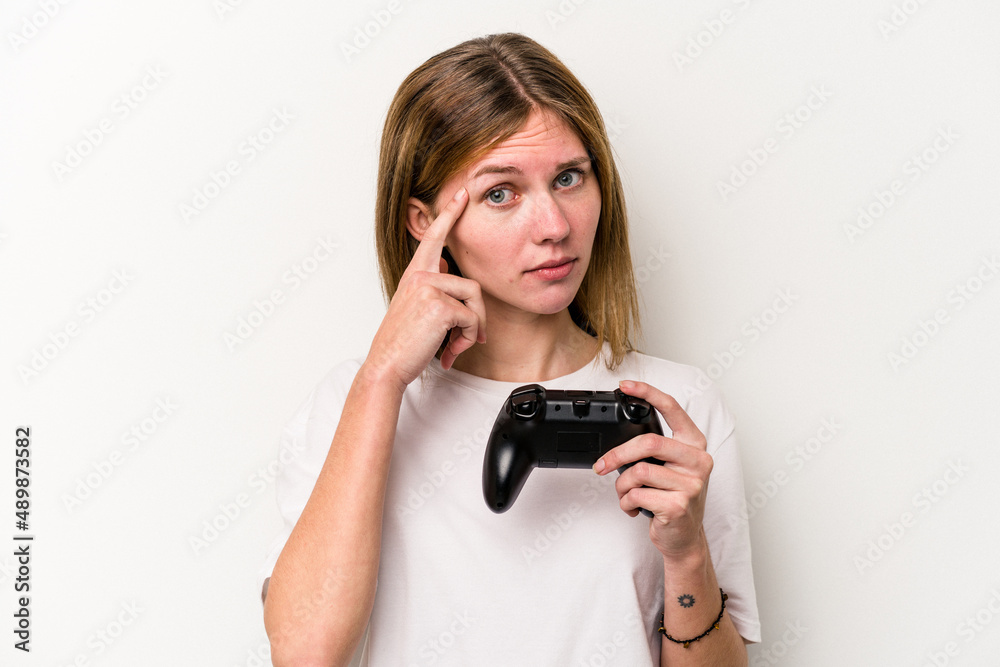 Young English woman playing with a video game controller isolated white background pointing temple with finger, thinking, focused on a task. Young English woman playing with a video game controller isolated white background pointing temple with finger, thinking, focused on a task.