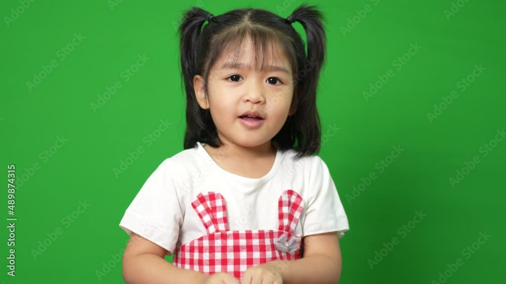 Portrait of happy and funny Asian child girl on green screen background, a child looking at camera. Preschool kid dreaming fill with energy feeling healthy and good concept Portrait of happy and funny Asian child girl on green screen background, a child looking at camera. Preschool kid dreaming fill with energy feeling healthy and good concept