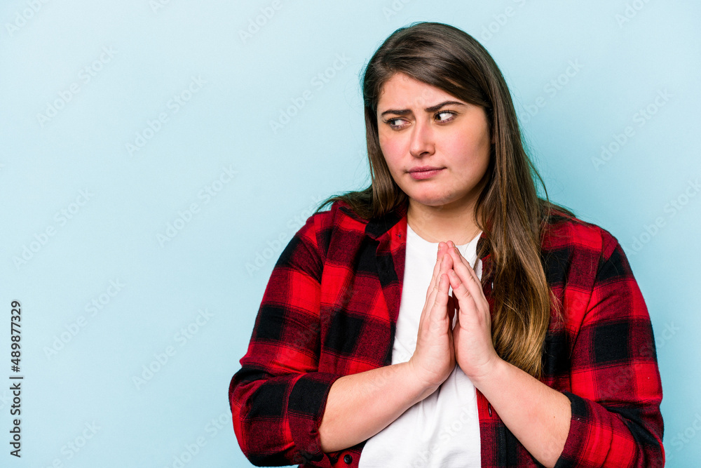 Young caucasian overweight woman isolated on blue background making up plan in mind, setting up an idea.