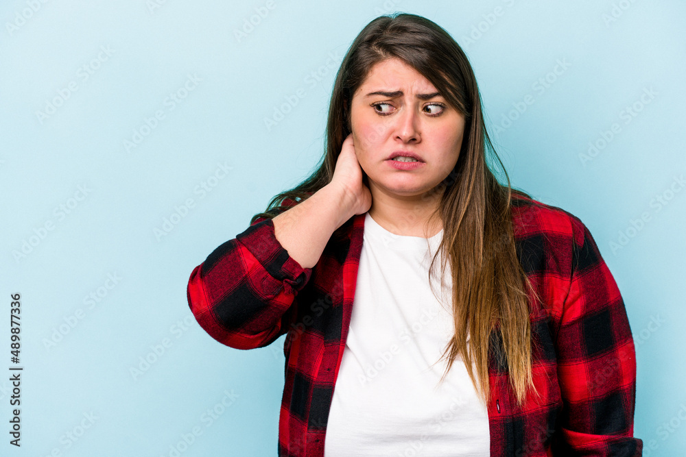 Young caucasian overweight woman isolated on blue background touching back of head, thinking and making a choice. Young caucasian overweight woman isolated on blue background touching back of head, thinking and making a choice.