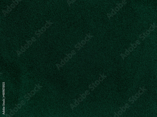 Dark green old velvet fabric texture used as background. Empty green fabric background of soft and smooth textile material. There is space for text..