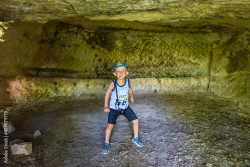 A little boy in the caves of the city of Tepe-Kermen in Bakhchisarai. Crimea. Russia. Crimean mountains. 2021