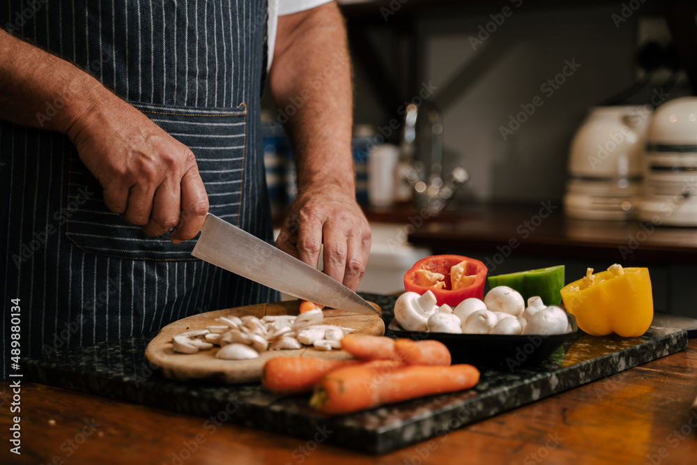 Caucasian senior male cooking dinner for wife 
