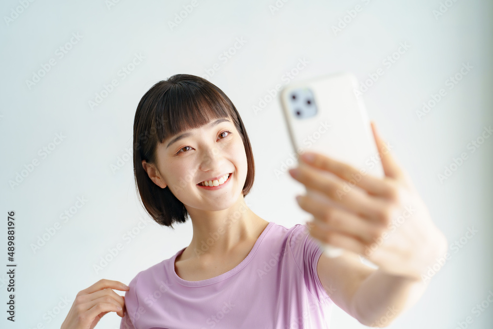 スポーツウェア姿でスマートフォンの画面を見る女性 スポーツウェア姿でスマートフォンの画面を見る女性