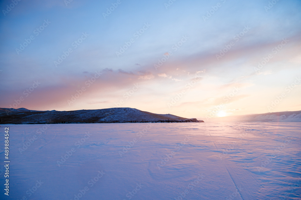 Winter landscape. Sunset on the frozen Lake Baikal