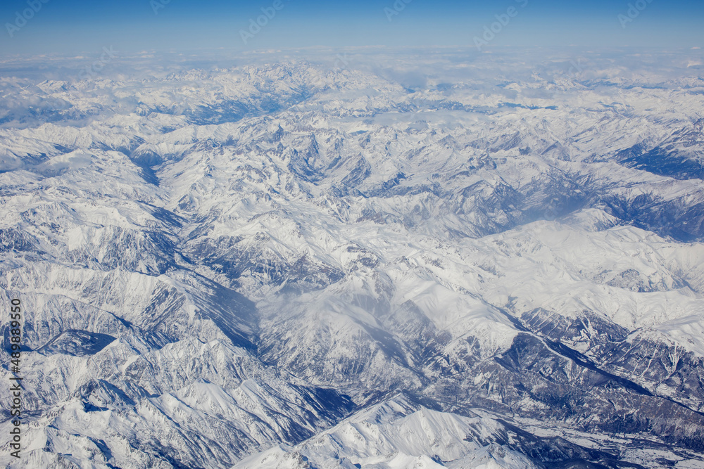 Panoramic view of snowy Alps from above, view from airplane window