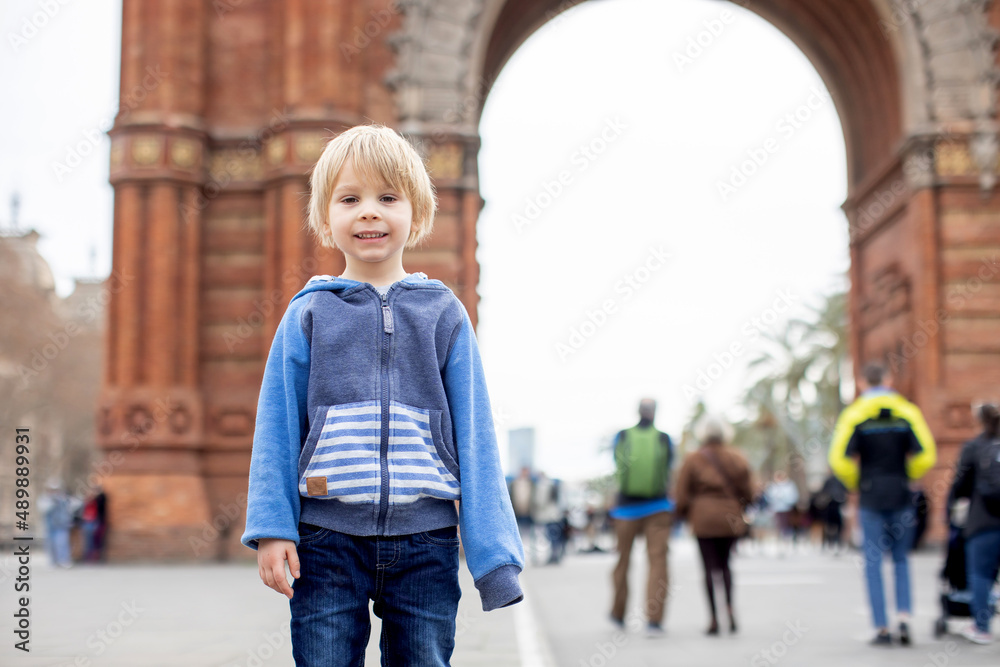 Cute little child, toddler boy, playing in front of Arc de Triumph in Barcelona city, family travel with kids