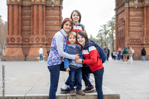 Cute children and mom  toddler boy  brothers and mother  enjoying Arc de Triumph in Barcelona city  family travel with kids