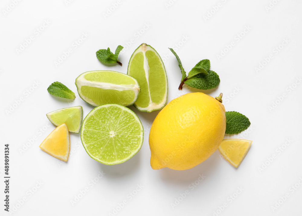 Fresh ripe lemons, limes and mint leaves on white background, top view