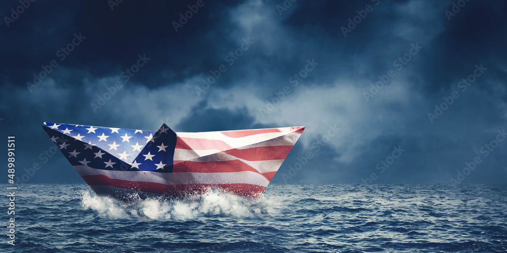 Paper boat with America flag floating on the sea