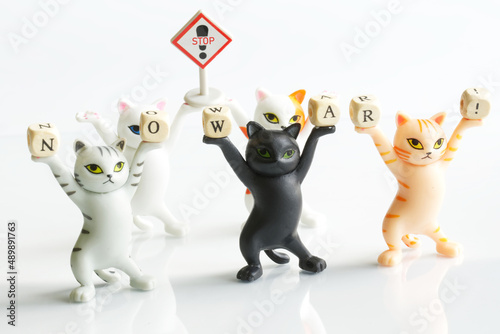 Cute toy kittens are holding cubes with the inscription no war and a sign with the inscription stop. The concept of protest against the war in Ukraine. Toy manifestation