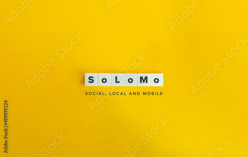 SoLoMo (Social, Local and Mobile) Buzzword and Banner. Letter Tiles on Yellow Background. Minimal Aesthetics.