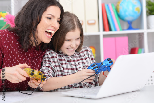 Portrait of mother and daughter playing computer game
