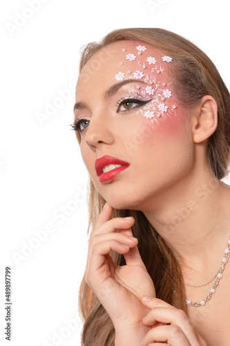 Portrait of young woman with creative make up on white background