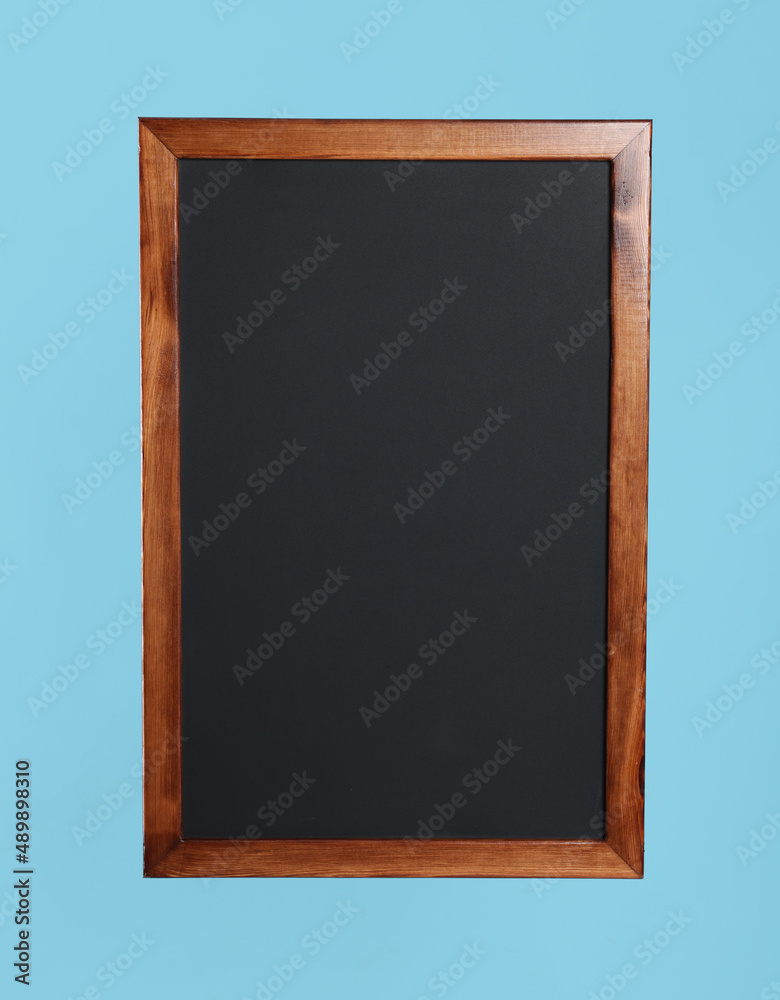Fototapeta premium Clean black chalkboard on light blue background