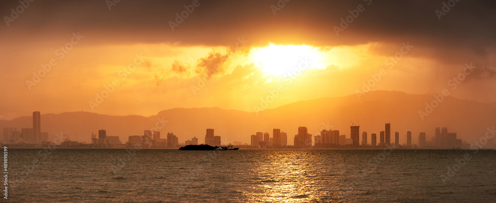 Beautiful scenery of a city skyline on a sunset with dramatic clouds of rain and storm