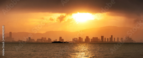 Beautiful scenery of a city skyline on a sunset with dramatic clouds of rain and storm