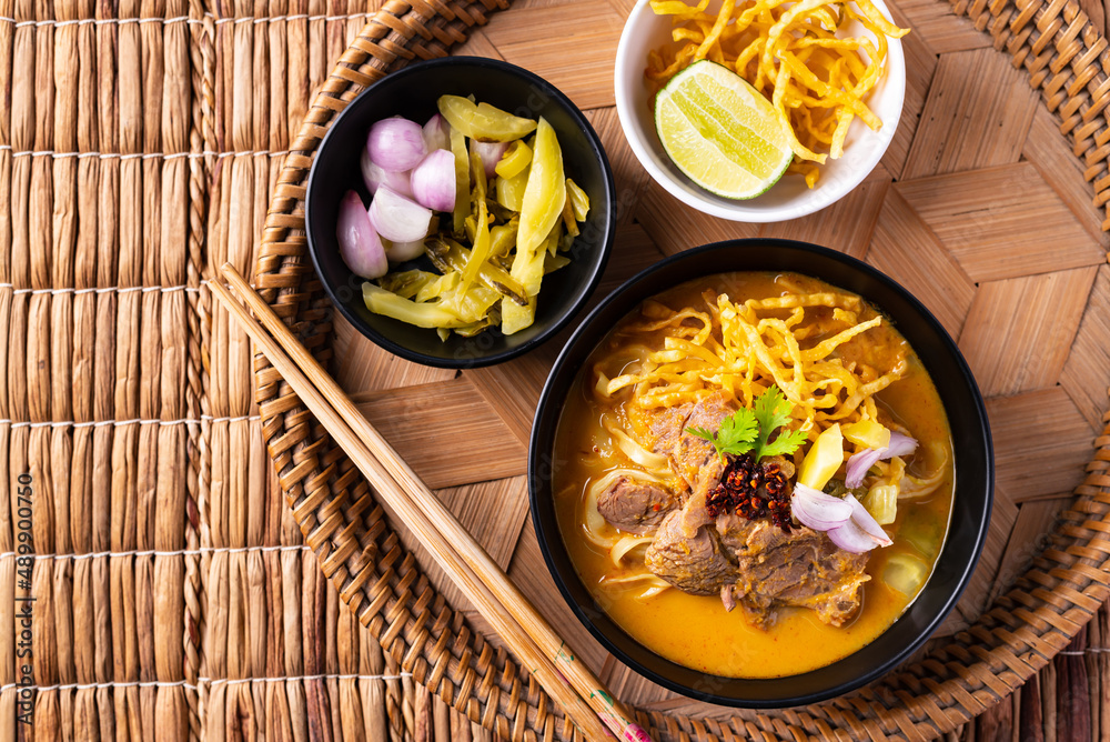 Northern Thai food (Khao Soi), Spicy curry noodles soup with coconut milk and beef, Local Thai food, Table top view Northern Thai food (Khao Soi), Spicy curry noodles soup with coconut milk and beef, Local Thai food, Table top view