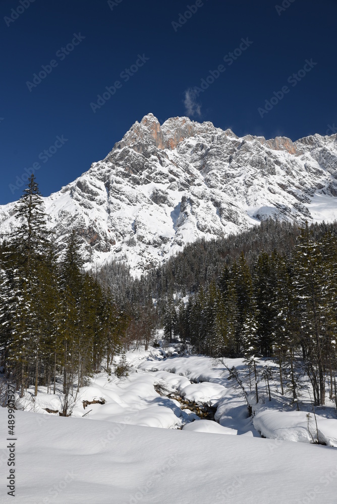 Fototapeta premium das hochkönig massiv im winter schnee blau himmel wolken pinzgau salzburg österreich alpen hochkönig austrian alps under a blue sky with dramatic clouds austrian alps salzburg