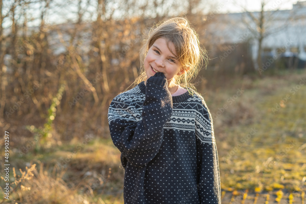 Lächelndes Gesicht: Ungezwungen spielt ein junges, hübsches, freundliches Mädchen im Abendlicht im Park. Sie hat schönes, langes, blondes Haar und bewegt sich in der Natur um gesund und fit zu bleiben Lächelndes Gesicht: Ungezwungen spielt ein junges, hübsches, freundliches Mädchen im Abendlicht im Park. Sie hat schönes, langes, blondes Haar und bewegt sich in der Natur um gesund und fit zu bleiben