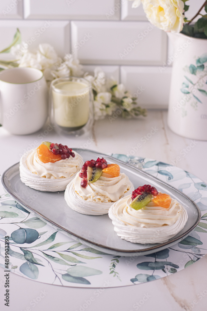 dessert pavlova with cream and fruits on gray plate white scandic ground white spring flowers matcha tea dessert pavlova with cream and fruits on gray plate white scandic ground white spring flowers matcha tea