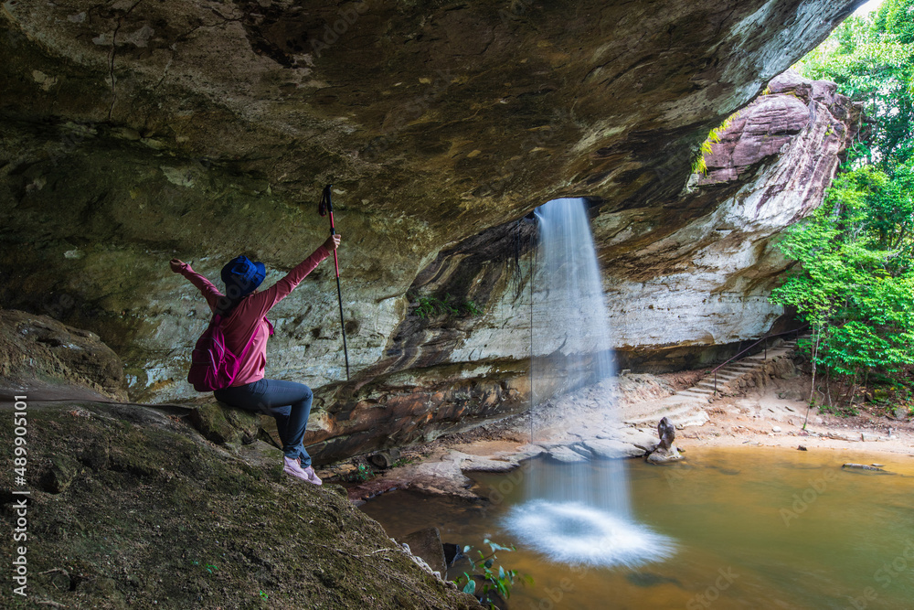 Obraz premium Young woman hiking in Sang Chan Waterfall, Beautiful waterfall in Pha Tam national Park, Ubon Ratchathani province, ThaiLand.