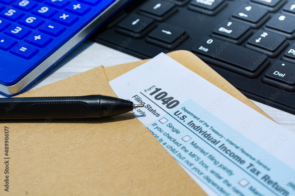 Tax forms 1040. U.S Individual Income Tax Return in an brown envelope on a desk. Tax forms 1040. U.S Individual Income Tax Return in an brown envelope on a desk.