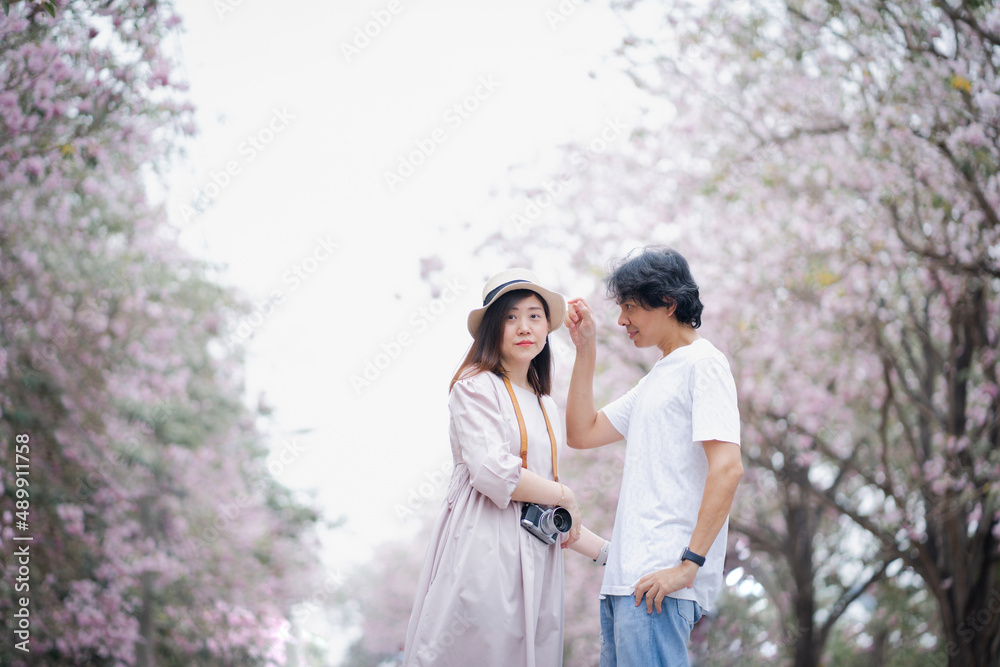 asian couple travel outdoor with  pink flower in springtime season