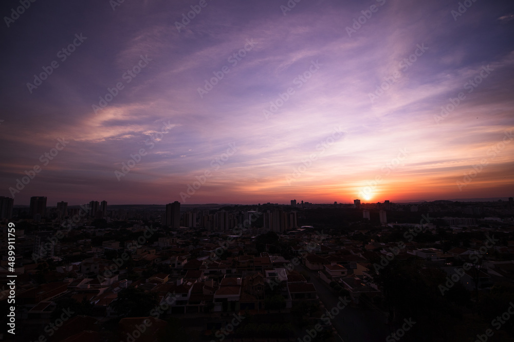 Naklejka premium Rising sun with city silhouette skyline. Cinematic sky in the Brazilian city.