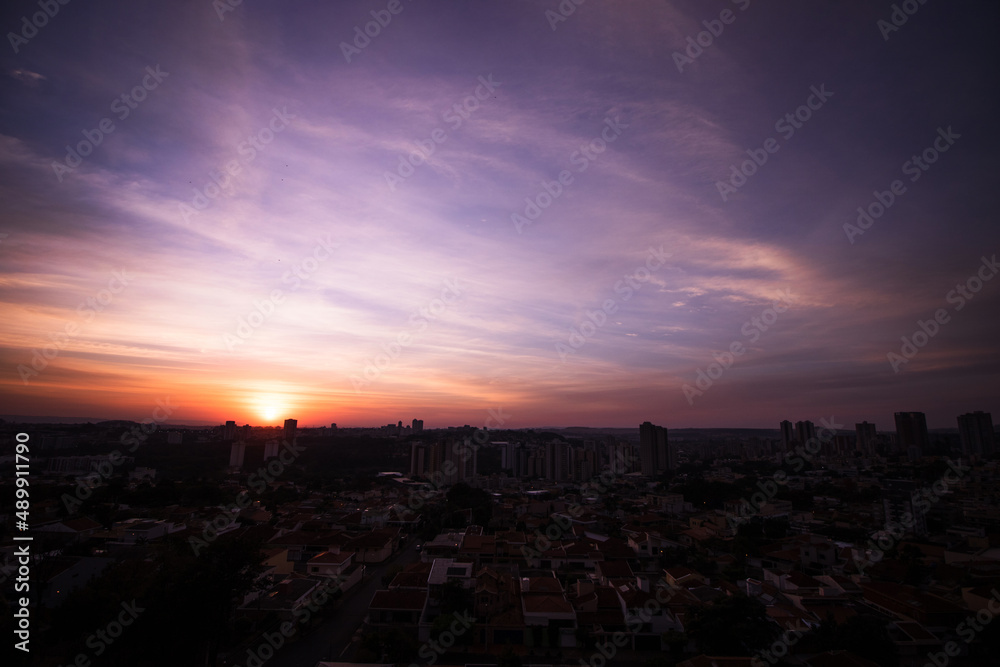 Rising sun with city silhouette skyline. Cinematic sky in the Brazilian city.