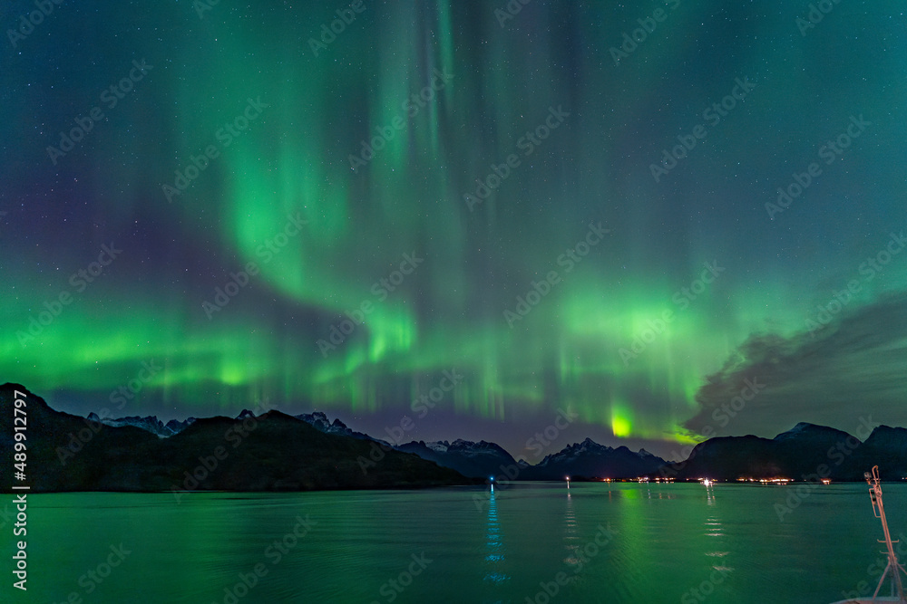 Nordlichter im Raftsund zwischen den Lofoten und den Vesteralen. Über den verschneiten Bergen tanzt die Aurora Borealis am sternenklaren Himmel! Grün, Weiss, Pink und Hellblau leuchtet das Nordlicht.