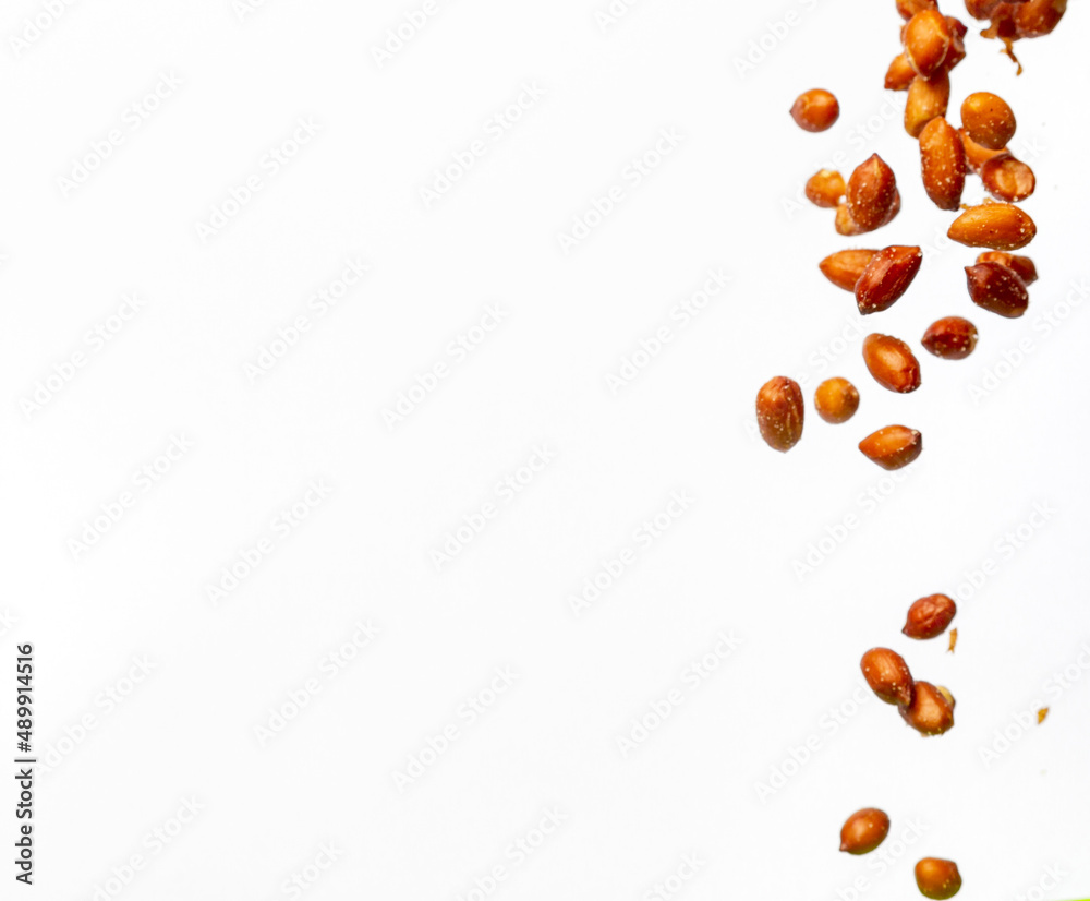 Peanuts falling on white background with copy space