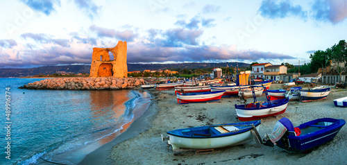 Picturesque beach scenery with tradtional fishing boats and saracen tower in Calabria. Landmarks of south Italy photo