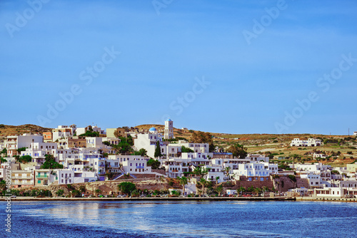 Beautiful sunny summer day in typical village of Greek island. Whitewashed houses and church. Mediterranean vacations. Milos, Cyclades, Greece.