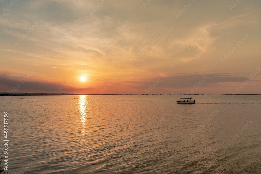 Beautiful landscape with boat in the middle of the lake during sunset